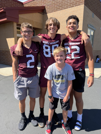 MMHS Football players posing with 4th graders