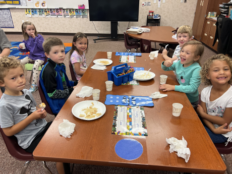 Kindergarten students eating pancakes