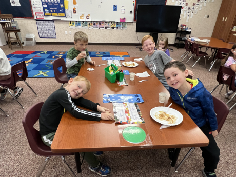 Kindergarten students eating pancakes