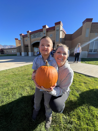 A student holding a pumpkin